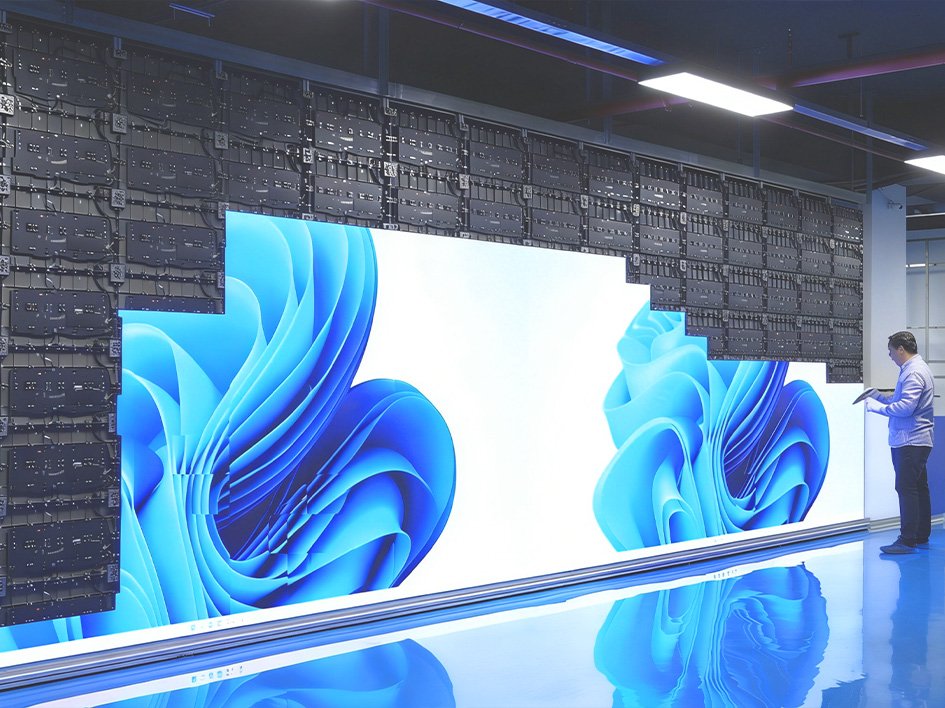 Technicians are installing a large, seamless COB LED video wall for a commercial project